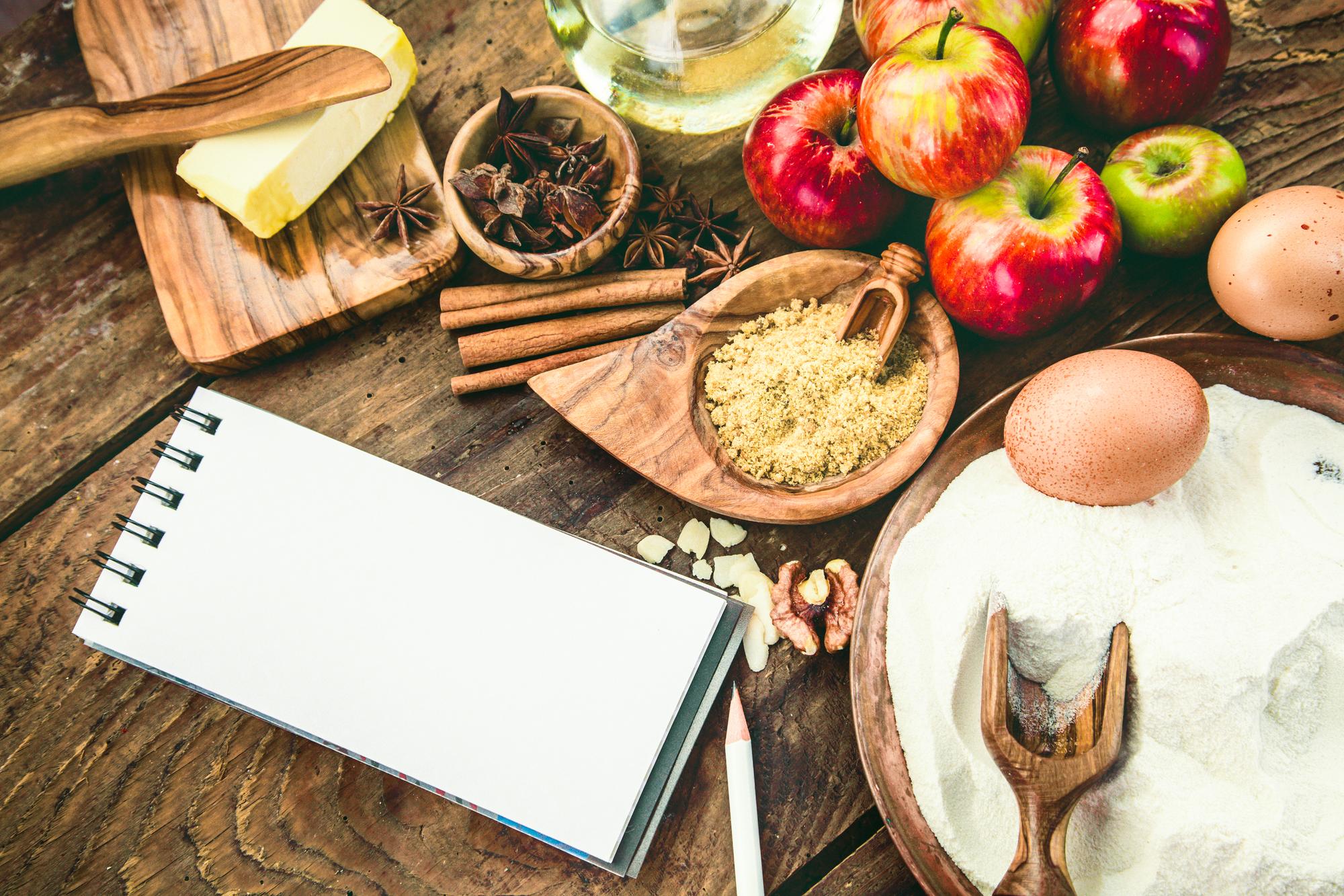 Mesa com ingredientes e cadernos de receitas